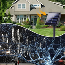 nzmegabuy solar fairy lights with 100 cold white LEDs illuminating a tree at night and a solar panel for charging