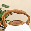 nzmegabuy 3L stainless steel whistling tea kettle featuring a white textured body and wood-look handle and lid knob.