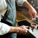 nzmegabuy barista using a stainless steel espresso tamper with a wooden handle to compress coffee in a portafilter