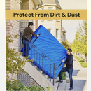 Two men carrying a blue RYANNA heavy duty tarp mattress storage bag with handles up a staircase during a move.
