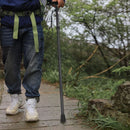 nzmegabuy black folding hiking pole with ergonomic grip being used on a paved outdoor trail