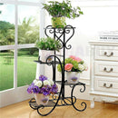 nzmegabuy black metal 4-tier plant stand with scrollwork design holding four potted plants in a bright room