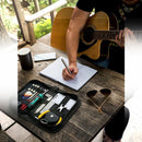 nzmegabuy 23-piece guitar repair kit with tools in a black zipper bag on a wooden table next to a musician